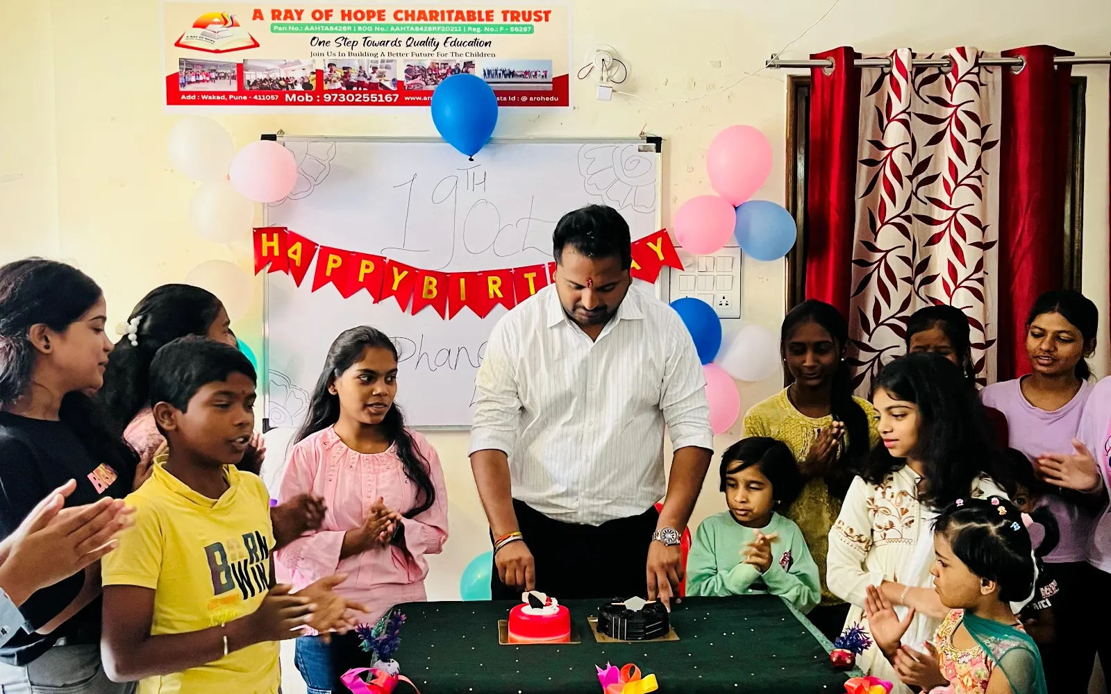 Dhanesh Indore cutting a cake with children at A Ray of Hope Charitable Trust